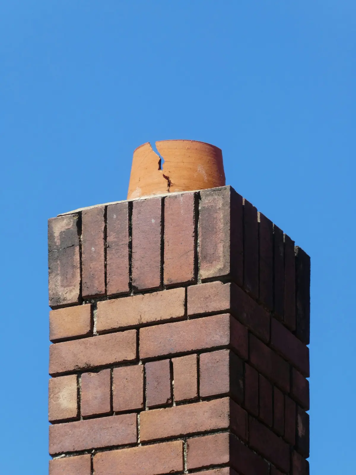 Brick chimney top against a blue sky